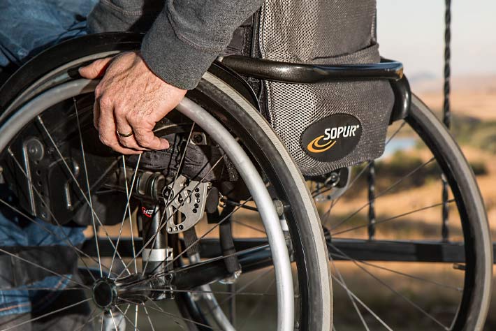 Detail of a wheelchair, including the backpack on the rear.
