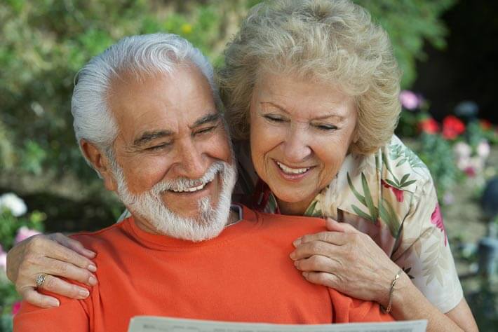 Happy older couple enjoying time outdoors while studying their Texas Medicare plan.