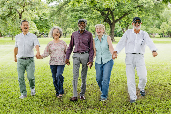 Group of older friends enjoying a day in the park, like many people who are on Medicare Insurance.